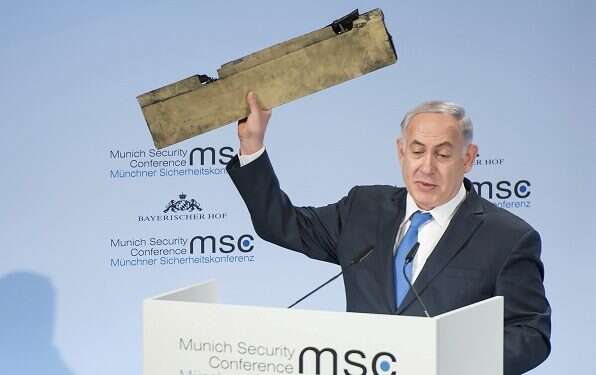 PM Benjamin Netanyahu holds a fragment of a downed drone during his speech at the Munich Security Conference PM: Israel won't allow Iran to put a 'noose of terror' around Israel's neck