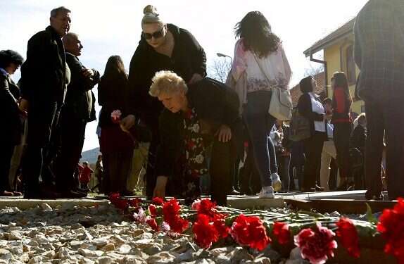 A man puts his arms on a freight wagon during a ceremony honoring victims of the Holocaust at the railway station in Bitola |