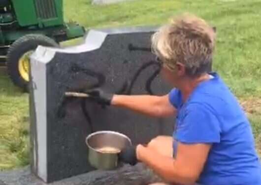 A woman scrubs a spray-painted swastika off a headstone at the Sunset Hills Cemetery in Glen Carbon Headstones defaced with swastikas in nonsectarian cemetery in Illinois