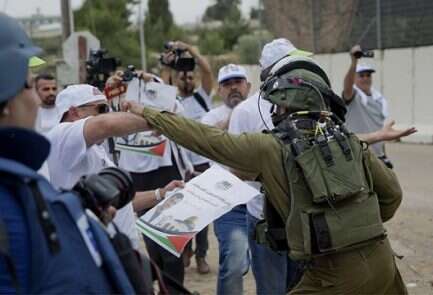 An Israeli soldier scuffles with a journalist during a protest near the West Bank city of Ramallah Knesset OKs bill banning filming of IDF soldiers in preliminary vote