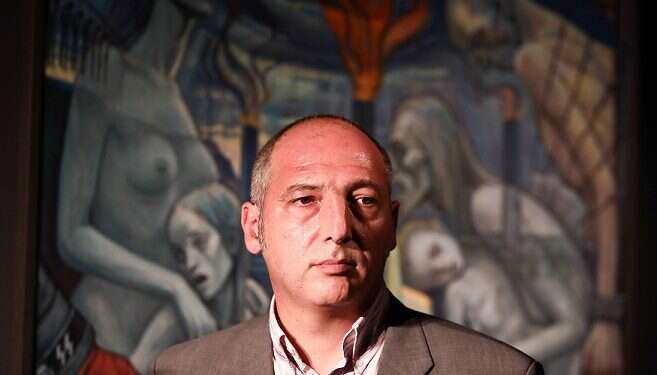 A man looks at a painting during the opening of an exhibition featuring works by David Olere ||