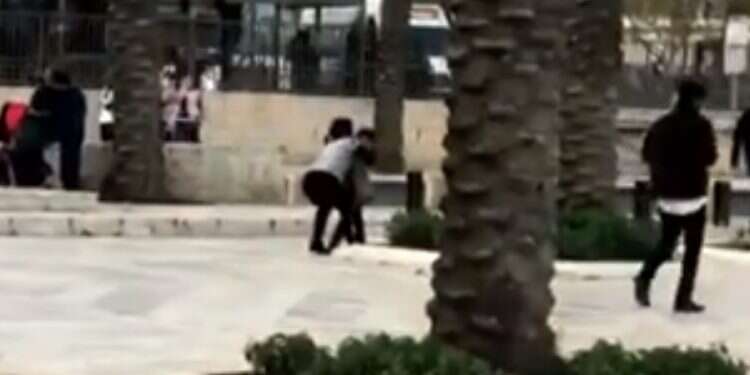 'Sarah,' center, reaches down to embrace her grandson, whom she is meeting for the first time Israeli woman smuggles matzah to grandchildren in Gaza