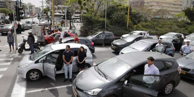 Israelis stand next to their cars in Tel Aviv as sirens mark a nationwide moment of silence in remembrance of the 6 million Jewish victims of the Holocaust Israel comes to a 2-minute standstill to honor Holocaust victims
