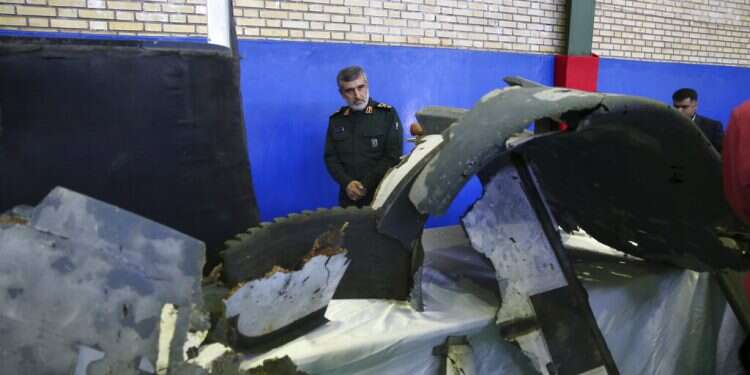 Head of the Revolutionary Guard's aerospace division Gen. Amir Ali Hajizadeh looks at debris from what the division describes as the U.S. drone which was shot down on Thursday, in Tehran, Iran, Friday, June 21, 2019 Iran says Revolutionary Guard shoots down US drone