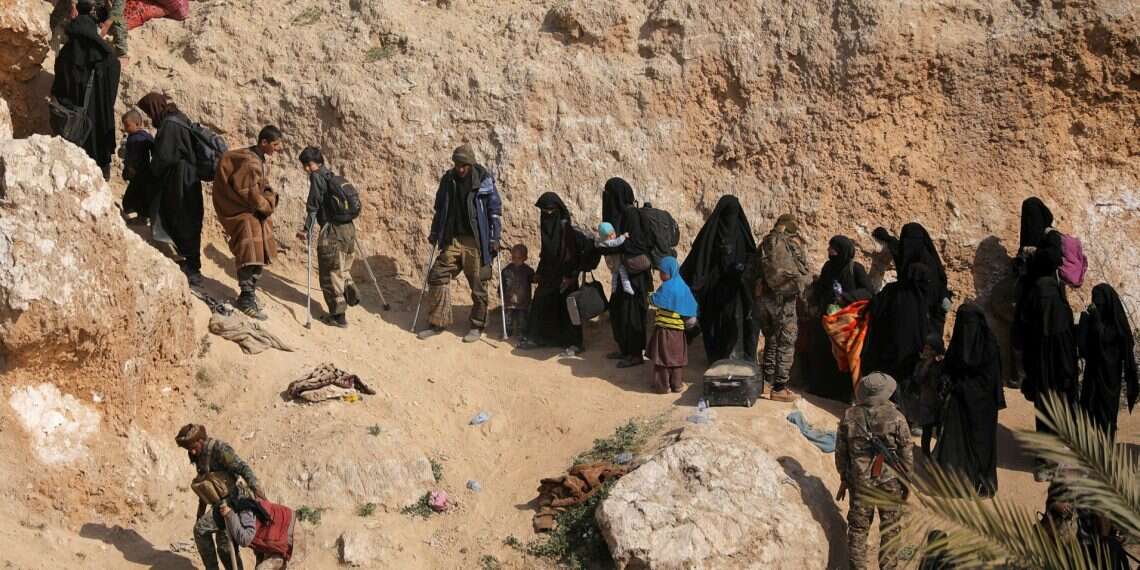Islamic State fighters and their families walk as they surrender in the village of Baghouz, Deir ez-Zor province, Syria, in March Australia repatriating 8 youth from Islamic State families