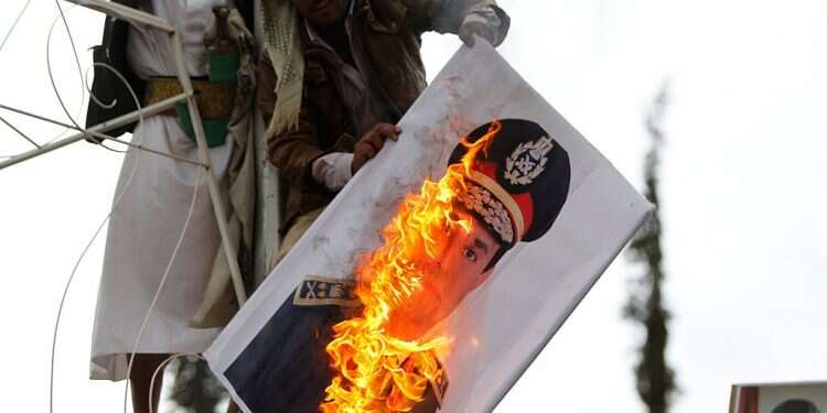 A protester in Yemen burns the image of Egyptian President Abdel Fattah el-Sissi in his army uniform after the 2013 coup that deposed former Egyptian leader Mohammed Morsi 'El-Sissi destroying Egypt according to 3,000-year-old plan from Jewish Bible'