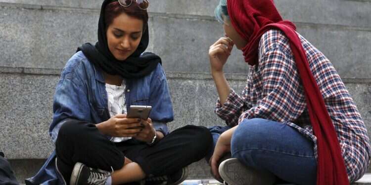 An Iranian woman works on her cell phone while spending an afternoon on steps outside of a shopping mall in northern Tehran Iranians manage to surf the web despite tide of censorship