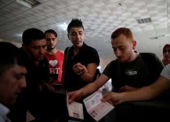 A Palestinian man, Hassan Al-Qun, 25, gestures as he wait for a travel permit before leaving Gaza to search for a job abroad, at a border crossing in Rafah, Gaza Strip, July 8, 2019 War, poverty drive Gazans to seek better life in Europe despite dangers