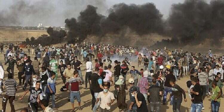 Palestinian protesters run from teargas fired by Israeli troops during a protest at the Gaza Strip's border with Israel in May 2018 6,000 Palestinians riot on border, hurling rocks, explosives at IDF troops