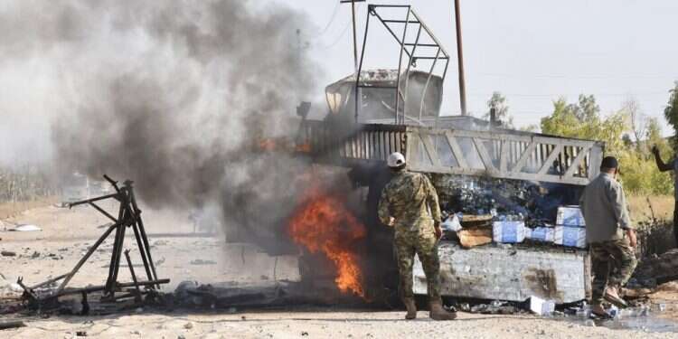 Popular Mobilization Forces members stand by a burning truck after a drone attack near the Qaim border crossing in Anbar province, Sunday Shiite groups in Iraq blame Israel for strike near Syrian border