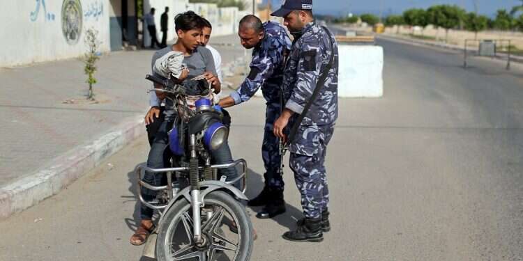 Hamas policemen search a motorcycle at a checkpoint in Khan Younis in the southern Gaza Strip Hamas: PA responsible for double suicide bombing in Gaza