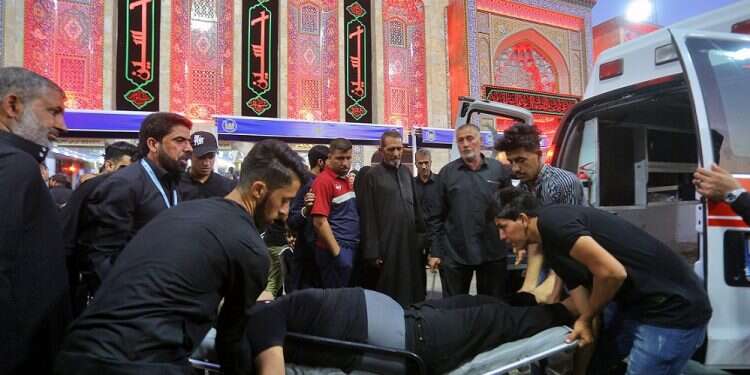People evacuate an injured man after a walkway collapsed and set off a stampede as thousands of Shiite Muslims marked one of the most solemn holy days of the year in the holy city of Karbala, Iraq, Tuesday Officials: 31 Iraqi pilgrims die in stampede during Shiite holiday