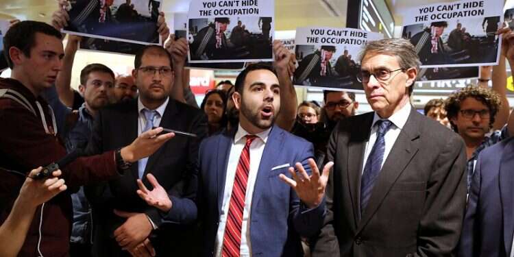 Omar Shakir (center) stands next to Executive Director of HRW Kenneth Roth while speaking before departing Israel at Ben-Gurion International Airport, Monday Israel deports Human Rights Watch director for advocating BDS