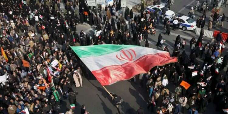 Demonstrators waves a huge Iranian flag in Mashhad, Iran, January 2018 Iran says hundreds of banks were torched in 'vast' unrest plot