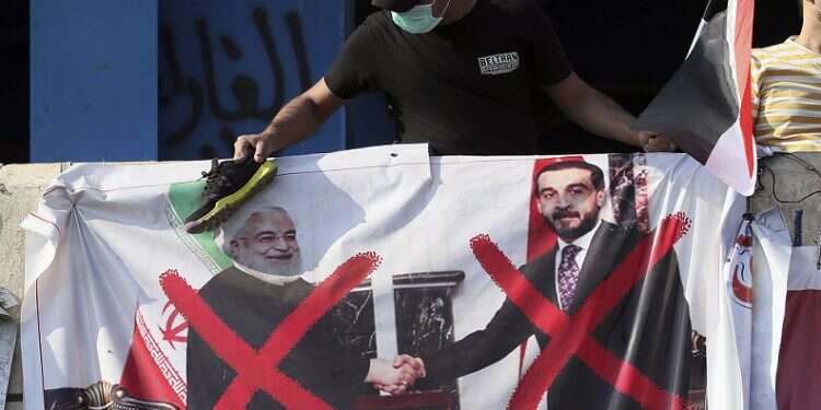 A poster of Iranian President Hassan Rouhani and Iraqi Parliament Speaker Mohammed al-Halbousi hangs on a building near Tahrir Square in Baghdad Report: Leaked intelligence cables show Iran's massive grip on Iraq