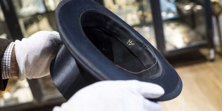 A man holds a hat with the initials of Adolf Hitler prior to the auction in Grasbrunn, Germany, last Wednesday Lebanese businessman buys Hitler items, is donating them to Israel