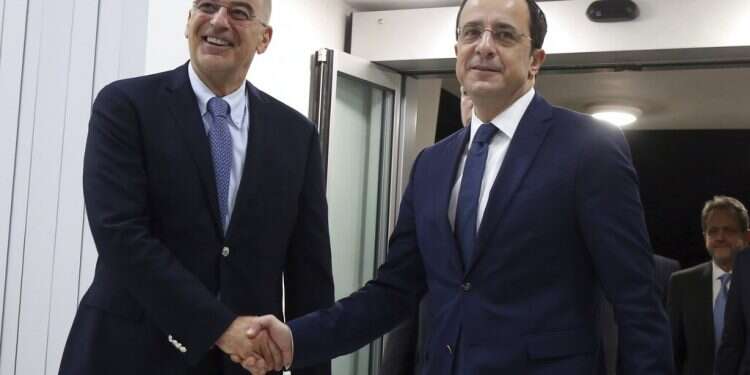 Greece's Foreign Minister Nikos Dendias, left, shake hands with Cypriot counterpart Nikos Christodoulides before their meeting at Cyprus' main airport in the coastal town of Larnaca on Sunday, Dec. 22 Israel, Cyprus, Greece to sign landmark gas pipeline deal on Jan. 2