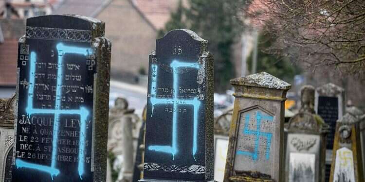 Headstones in a Jewish cemetery in France are seen defaced with blue swastikas Over 40 gravestones vandalized at Jewish cemetery in Germany