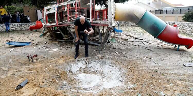 A man photographs the damage caused after a rocket landed in a playground in Sderot on Monday Shaky ceasefire appears to be holding hours after announced