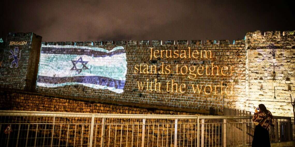 The Israeli flag on Jerusalem’s Old City walls, Thursday 'Jerusalem stands with the world,' city walls declare