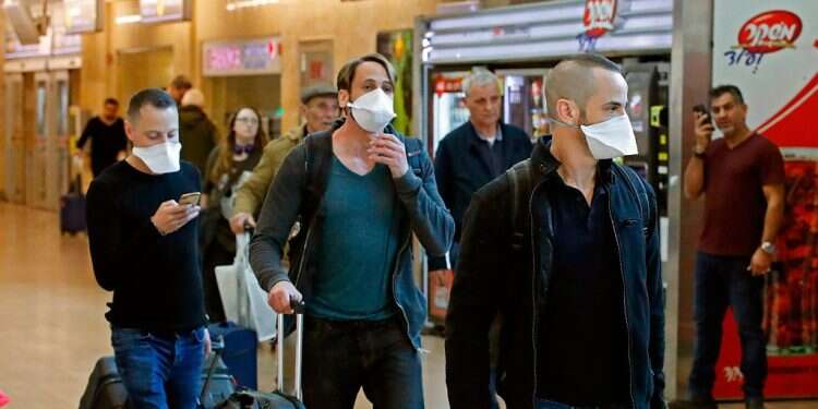 Travelers arrive at Ben-Gurion International Airport wearing face masks PM: Israelis returning from western Europe will be quarantined