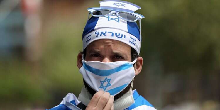 A man wears a protective face mask featuring the Israeli flag in Jerusalem Israel's population hits 9.2 million for 72nd Independence Day