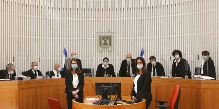 A panel of 11 Israeli High Court judges arrive wearing face masks to hear arguments against the legality of Prime Minister Benjamin Netanyahu’s coalition deal with his former rival, Benny Gantz, at the Israeli Supreme Court in Jerusalem, Monday Netanyahu may form government, High Court unanimously rules