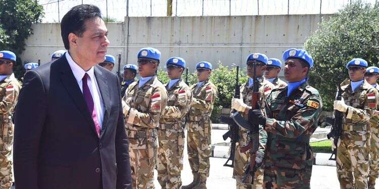 Lebanese Prime Minister Hassan Diab reviews the honor guard of the United Nations peacekeepers, upon his arrival at their headquarters in the southern coastal border town of Naqoura, Lebanon, Wednesday Lebanese PM visits UN peacekeepers amid dispute over mandate
