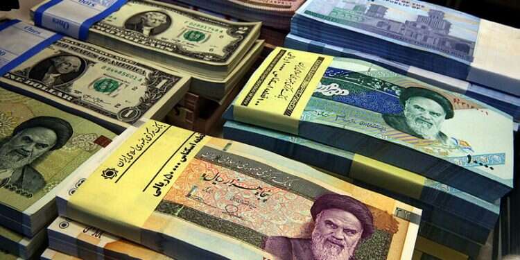 Iranian and US banknotes are on display at a currency exchange shop in downtown Tehran, Iran Resident of Alaska accused of laundering $1 billion for Iran