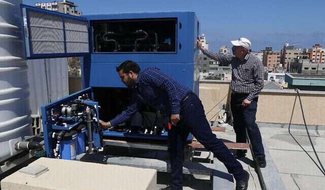 Palestinian engineer Raed Nakhal from Palestine Children Relief Fund checks the GEN-M machine that generates safe drinking water from air at the roof of al-Rantisi pediatric hospital in Gaza City, April 30 Israel donates 3rd water generator to Gaza Strip