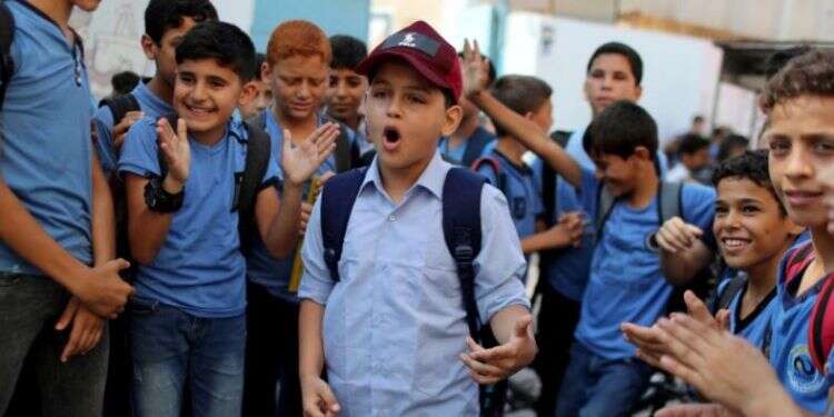 Abdel-Rahman Al-Shantti, an 11-year-old Gaza rapper, is surrounded by students as he performs in his school in Gaza City, Aug. 16, 2020 Gaza rapper, 11, strikes chord with rhymes about war, hardship