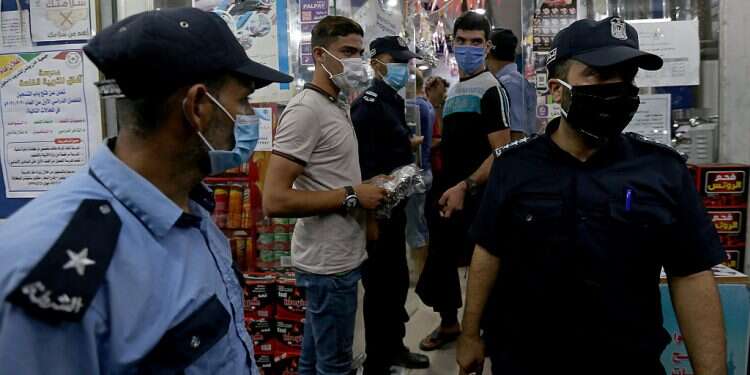 Palestinian police officers guard outside a shop after Gaza reported its first cases of COVID-19 in the general population Hamas orders lockdown in Gaza over coronavirus outbreak