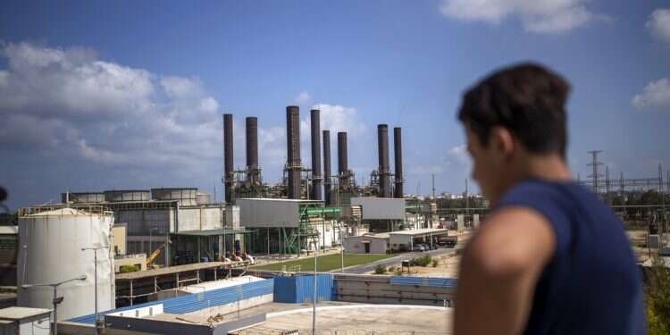 A Palestinian man looks at Gaza's power plant in the town of Nusairat after it was shut down Tuesday Gaza's power plant shuts down amid Israel-Hamas escalation