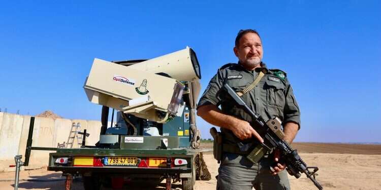 Border Police commander Kobi Shabtai stands next to the Lahav Or (Light Blade) laser interceptor 'Light Blade' laser system intercepts nearly 100% of Hamas balloons in its sector