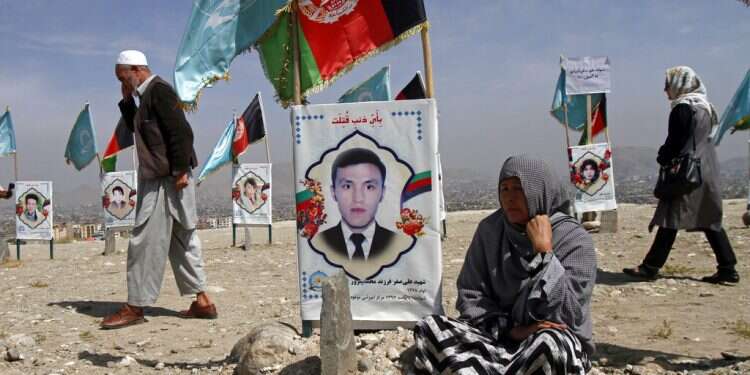 An Afghan woman sits next to the grave of her son outside Kabul, Monday US Embassy in Afghanistan warns of extremist attacks against women