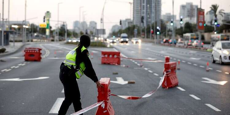 A police officer in Ashdod fixes barriers at a check point as Israel enters a nationwide lockdown, Sept. 21. 2020 Cabinet backs full lockdown as corona outbreak proves relentless