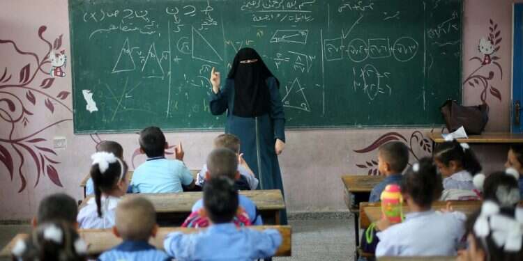 A Palestinian teacher gives a math lesson at a UN-run school, in Khan Yunis, Gaza Report: Palestinian textbooks remain openly anti-Semitic despite revision promise