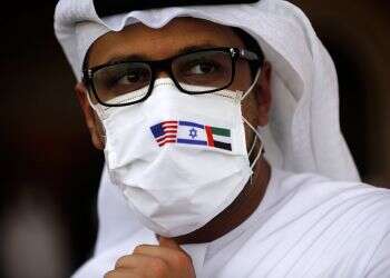 A man wearing a mask bearing the national flags of US, Israel and UAE, looks on after disembarking from Israeli flag carrier El Al's flight to Abu Dhabi, Aug. 31, 2020 (EPA/Nir Elias/File) UAE delegation to visit Jerusalem
