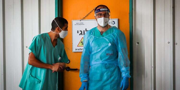 Medical workers at Shaare Zedek Medical Center in Jerusalem. The number of patients listed in serious condition has dropped below 600 for the first time in months 1,165 new COVID cases confirmed with 3% of tests positive