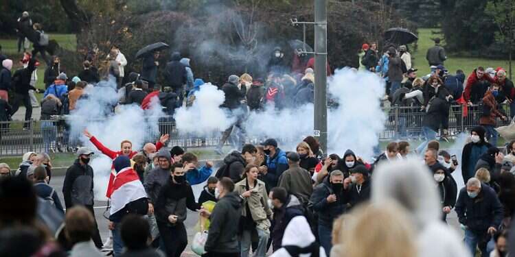 Demonstrators react as a stun grenade explodes during an opposition rally to reject the presidential election results in Minsk, Belarus Oct. 11, 2020 Belarus police crack down on protesters, detain dozens