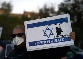 A woman holds a Jews Fight Back sign as members of the Sephardic Jewish Community in Brooklyn, New York gather to protest Mayor Bill Deblasio's closing of businesses and new lockdown in their neighborhood, Oct. 8, 2020 Poll: 69% of US Jews say Republican Party holds anti-Semitic views