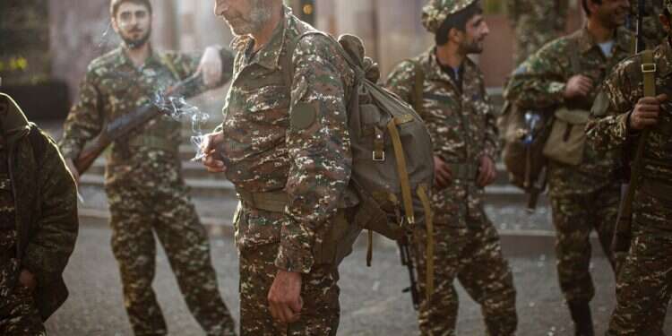 In this Sept. 29 photo, ethnic Armenian volunteer recruits gather at a center to receive their uniforms and weapons before being dispatched to the frontline near Hadrut Fighters from all over the Middle East jumping into Armenia-Azerbaijan conflict