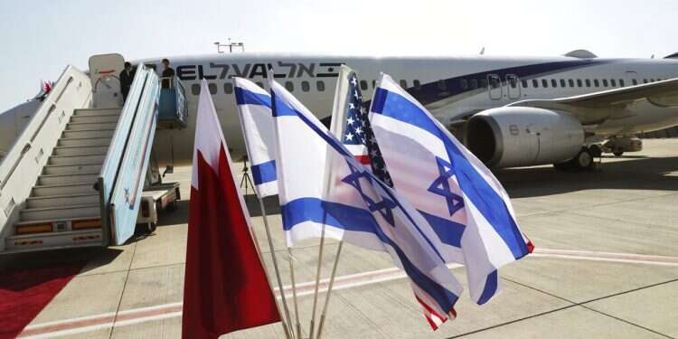 The national flags of Bahrain, Israel and the US flutter in near the El Al plane slated to make the company's first ever flight to Manama, Oct. 18, 2020 US, Israeli envoys fly to Bahrain to advance nascent ties