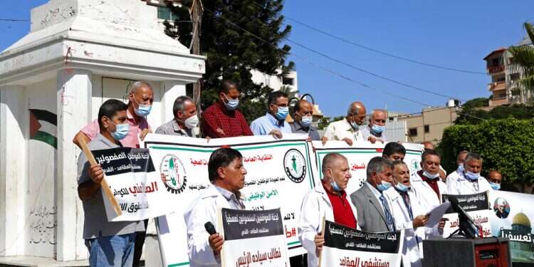 Medical workers wear face masks while staging a sit-in protest at the Unknown Soldier Square in Gaza City, Wednesday, Oct. 21, 2020 Gaza nurses protest loss of Israeli permit, layoffs