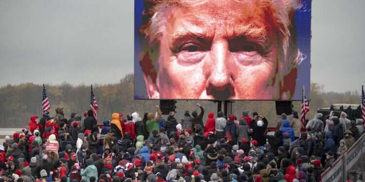 Supporters of US President Donald Trump watch a video during a campaign event on Tuesday, Oct. 27, in Lansing. Michigan Closing in on the goal