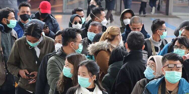 Mask-wearing tourists wait for a train at Seoul Station in Seoul, South Korea on Feb. 21 New report warns coronavirus outbreak set to worsen over winter