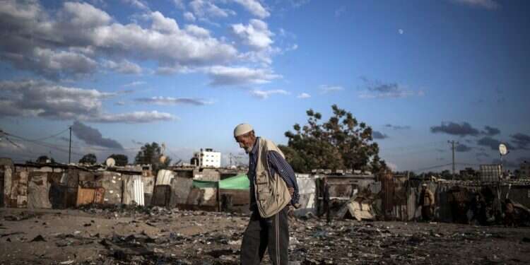 An elderly Palestinian man walks in a slum on the outskirts of Khan Younis, in the southern Gaza Strip UN agency accuses Israel of 'devastating' Gaza's economy
