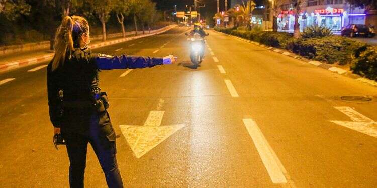 A police officer stops a motorcyclist at a blockade in Tel Aviv during Israel's second lockdown '3rd lockdown unavoidable,' interior minister warns