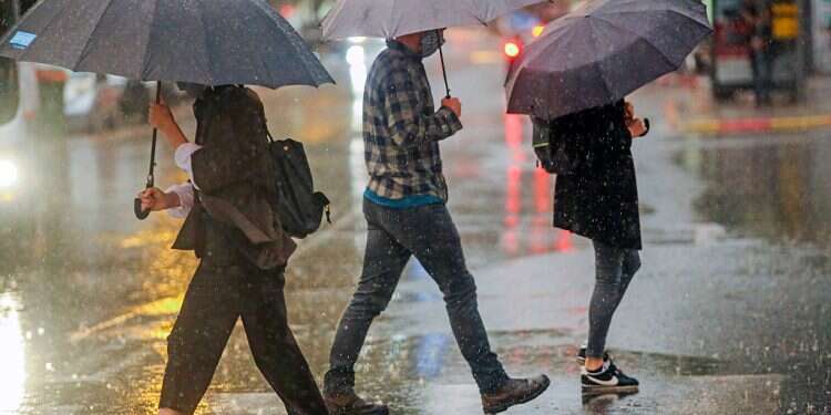 Tel Avivians scurry around under umbrellas, Thursday Coastal Israel drenched by heaviest November rainfall in 26 years