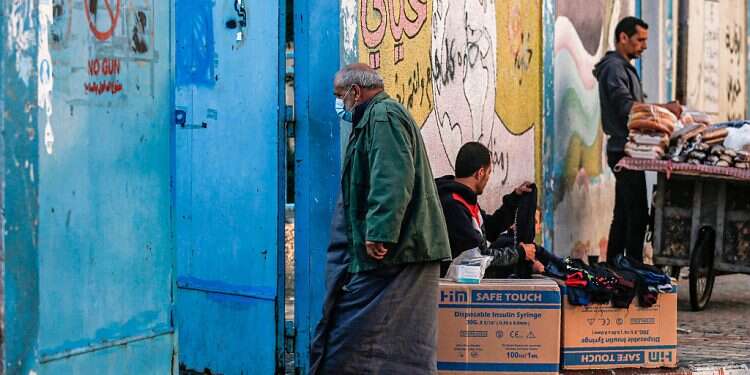 A Palestinian, mask-clad due to the COVID-19 coronavirus pandemic, enters
a health center Gaza's health system may soon collapse due to COVID-19